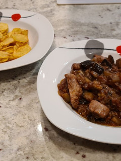 Una foto de Solomillo con berenjenas y patatas chips