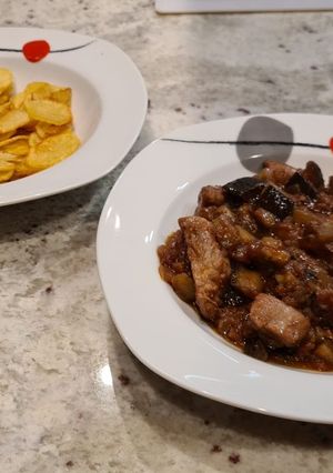 Una foto de Solomillo con berenjenas y patatas chips