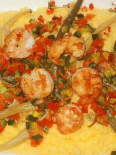 Una foto de Polenta orgánica con camarones salteados