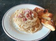 Una foto de pasta con crema de leche y tocineta