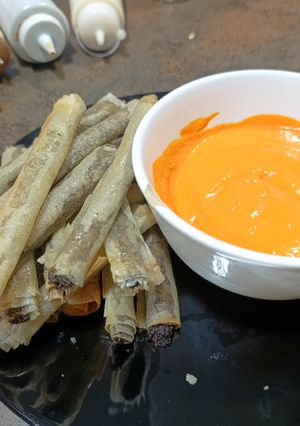 Una foto de Cigarros de Morcilla y Manzana Verde con Crema de Piquillos, aperitivo que gusta a todo el mundo