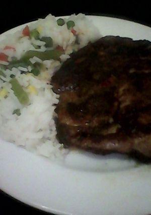 Una foto de Chuleta adobada con arroz primavera