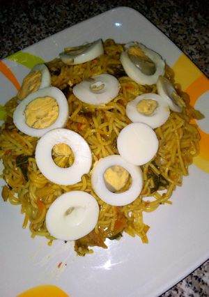 A picture of Spaghetti joloff with boiled egg.