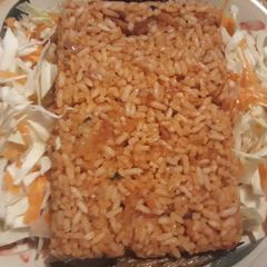 A picture of Jollof rice with coleslaw.