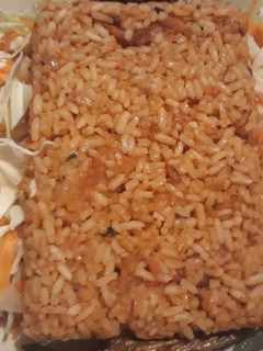 A picture of Jollof rice with coleslaw.