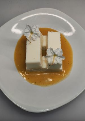 Una foto de Panna cotta de coco con coulis de maracuyá 🍮