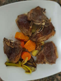 Una foto de Costillitas de cordero, con verduras al horno