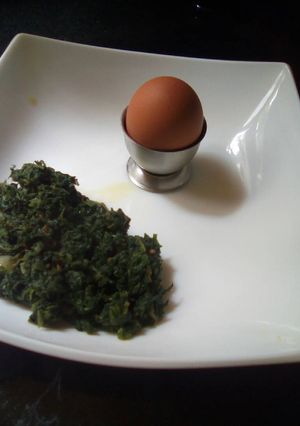 A picture of Fried pumpkin leaves and boiled egg.