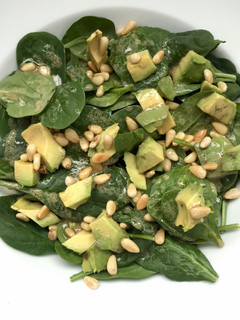 Una foto de Ensalada de espinaca con aguacate y piñones