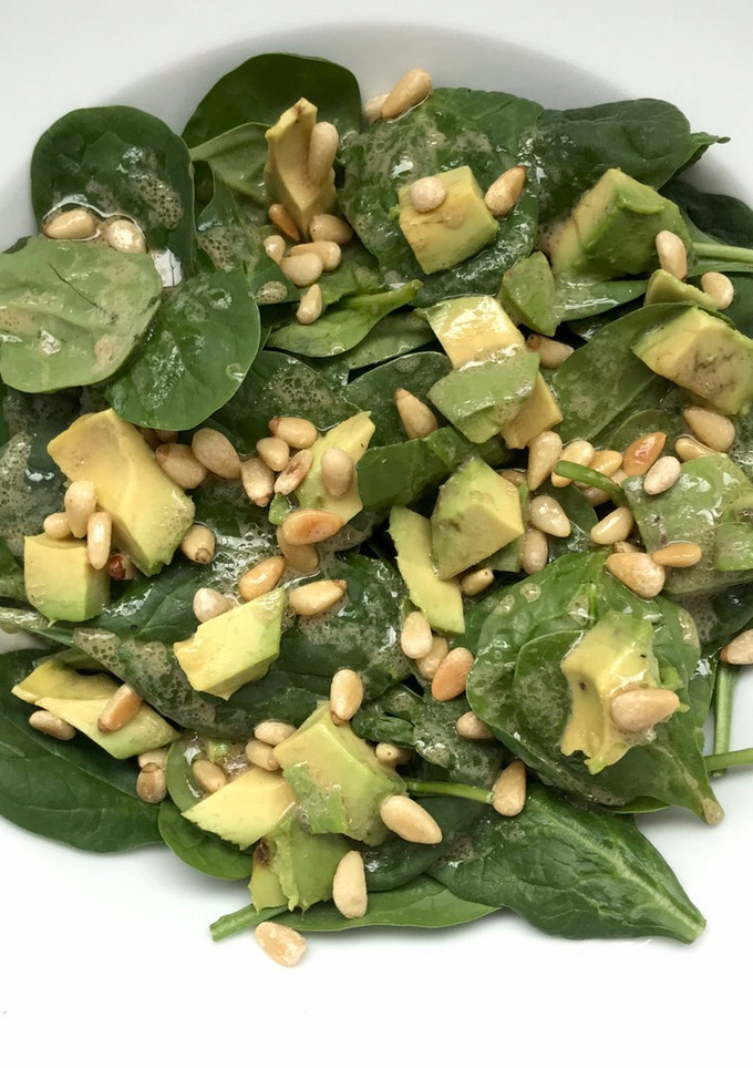 Una foto de Ensalada de espinaca con aguacate y piñones