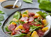 Una foto de ensalada con salami