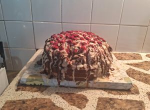 Una foto de Torta deleite con triple rellenos decorada con ganache de chocolate blanco y frambuesas