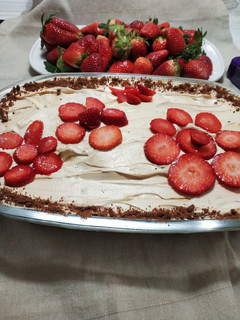 Una foto de Tarta de chocolinas con chantillí, dulce de leche y frutilla