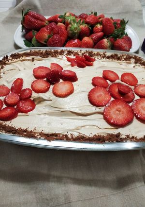 Una foto de Tarta de chocolinas con chantillí, dulce de leche y frutilla