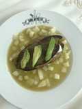 Nopal relleno de frijoles y queso panela sobre una capa de chayote y papa en salsa verde