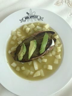 Una foto de Nopal relleno de frijoles y queso panela sobre una capa de chayote y papa en salsa verde