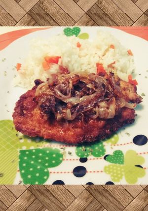 Una foto de Milanesa de pollo con cebolla caramelizada