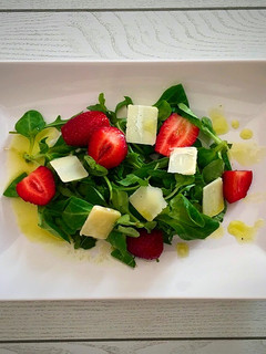 Una foto de Ensalada de rúcula y canónigos con fresas y parmesano