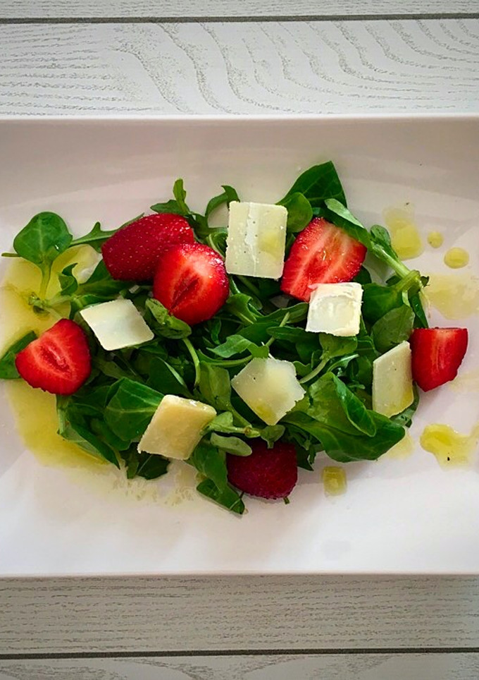 Una foto de Ensalada de rúcula y canónigos con fresas y parmesano