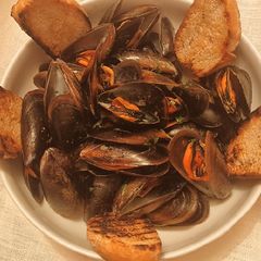 A picture of Mussels with white wine, parsley and bread.