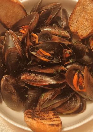 A picture of Mussels with white wine, parsley and bread.