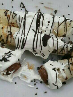Una foto de Panqueques rellenos de dulce de leche bañado con crema y chocolate