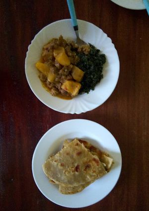 A picture of Beef stew, and greens with chapatti.