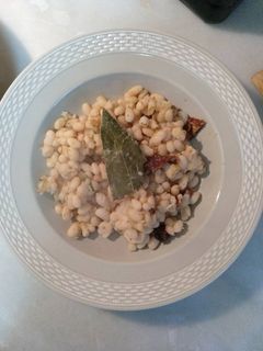 Una foto de Alubias blancas con tomate seco, limón y comino