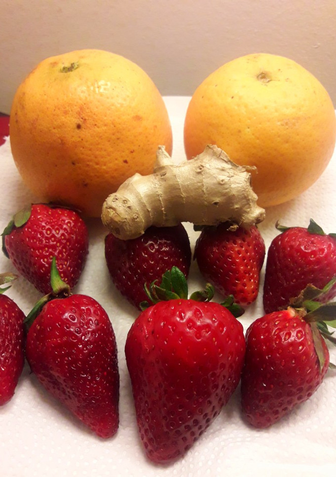 Una foto de Jugo de naranja, frutillas y jengibre