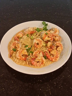 A picture of Poached Shrimp with Siriacha Cream Sauce on Angel Hair Pasta.
