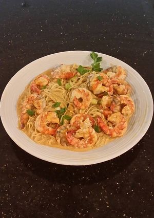 A picture of Poached Shrimp with Siriacha Cream Sauce on Angel Hair Pasta.