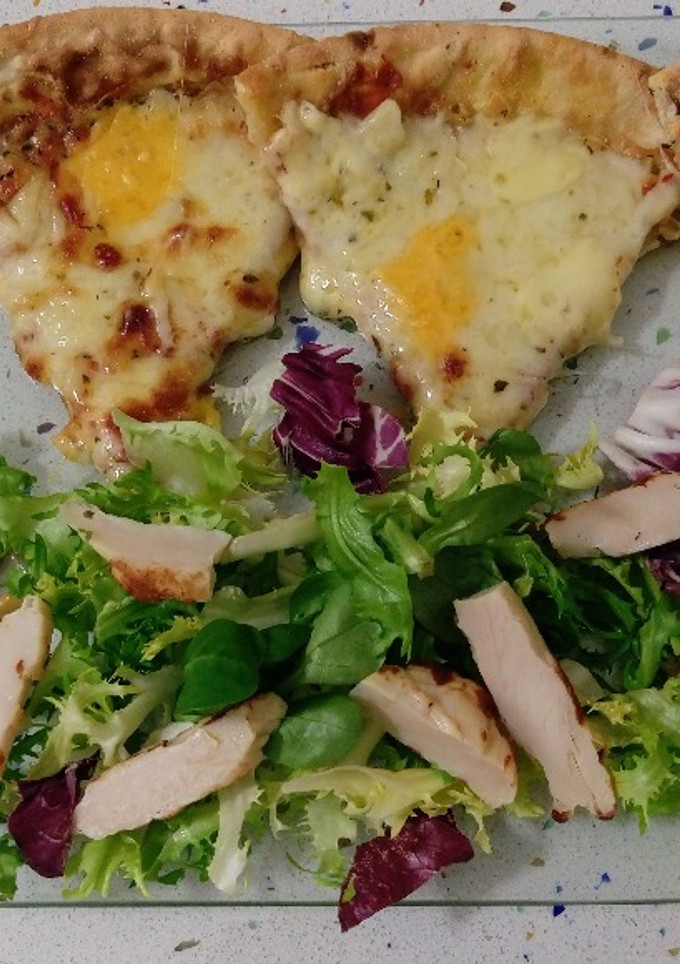 Una foto de Pizza de quesos con hierbas provenzales y ensalada de pollo