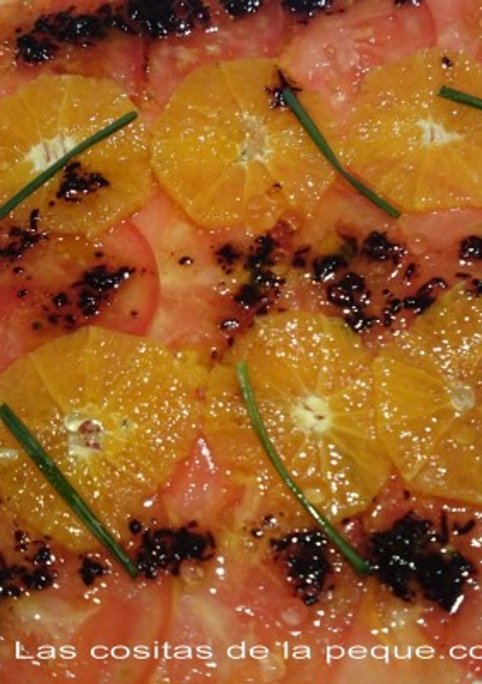 Una foto de Carpaccio de tomate y naranja con vinagreta de ajo negro