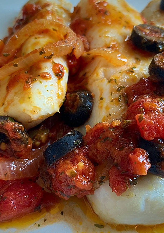 Una foto de Merluza al horno con tomate y anchoas