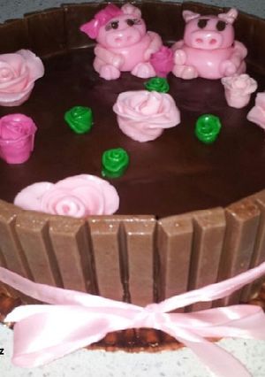 Una foto de Tarta de kitkats con cerditos en barro y relleno de trufa y crema pastelera
