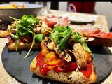 Tosta de pimiento caramelizado, tomate confitado, melva y rúcula
