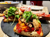 Tosta de pimiento caramelizado, tomate confitado, melva y rúcula