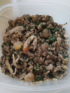Una foto de Arroz negro con espinacas, gambas y tallarines de surimi