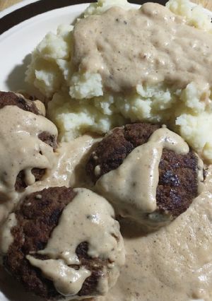 A picture of Gravy smothered hamburgers and mashed potatoes.