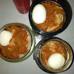 A picture of Spaghetti,boiled egg and tomato sauce.