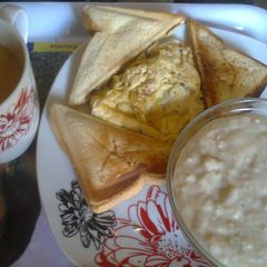 A picture of Toated bread,fried Eggs, Oatmeal and Tea.