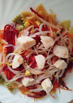 Una foto de Ensalada de pajarita con pollo y maíz dulce, zanahorias, remolacha y brotes germinados. Eliges aliño