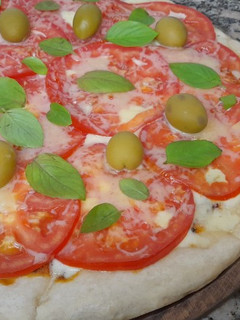Una foto de Pizza media masa caprese