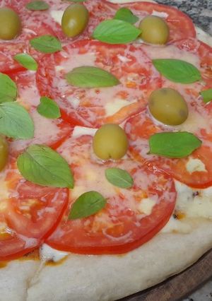Una foto de Pizza media masa caprese
