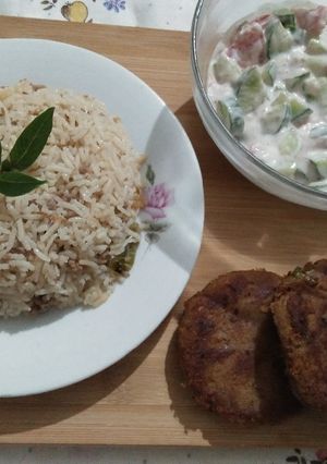 A picture of Qeemay rice with shami kabab and vegetables salad.