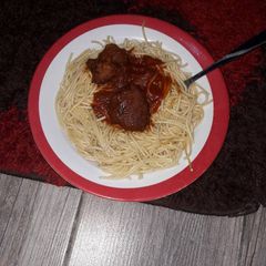 A picture of Spaghetti with goat meat tomato sauce.