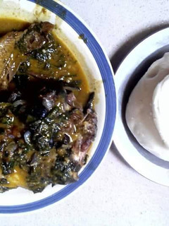 A picture of Bitterleaf soup with snail and akpu.
