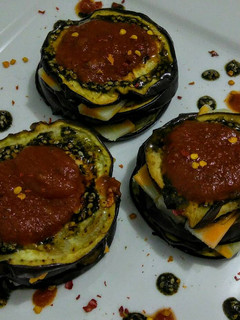 Una foto de Berenjenas asadas bañadas en zatar y tomate con queso mozzarella
