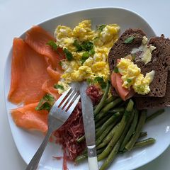 A picture of Scrambled eggs with smoked salmon and green beans.