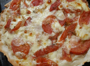 Una foto de Tarta de cebolla, tomate, queso y salsa blanca